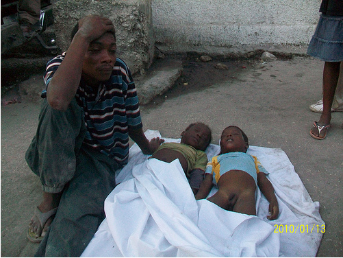 haiti-man-child Man sits outside Médecins Sans Frontières (MSF) the day after Haiti's earthquake. "God gives them and God takes them away," he said. (Photo by Vladimir Leguerre